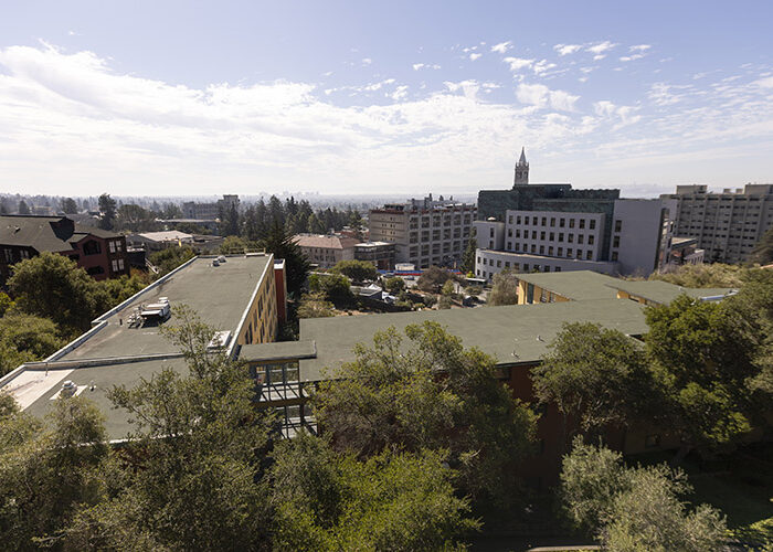 The view from a Foothill building window overlooks many trees, buildings, and structures in the distance, including the Campanile.